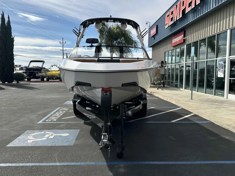 Slide: The Image of 2025 Axis T220 boat parked outside dealership, front view, in a handicap parking space. - 6