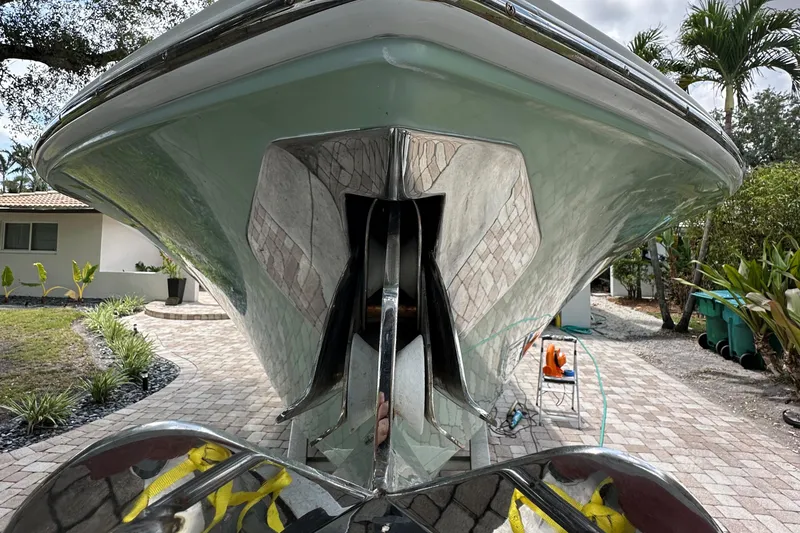Slide: The Image of 2014 Sailfish 320 CC boat on a driveway, showcasing its sleek hull design. - 14