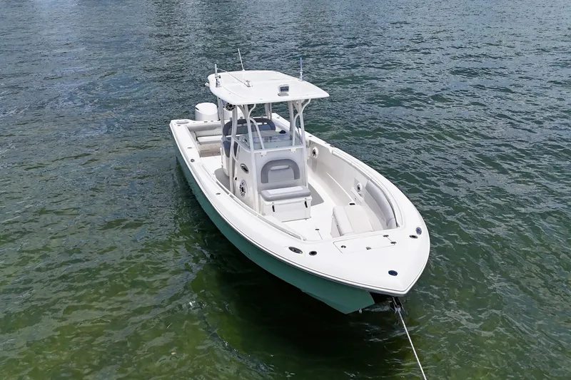 Slide: The Image of 2014 Sailfish 320 CC boat on calm water, showcasing sleek design and spacious deck. - 3