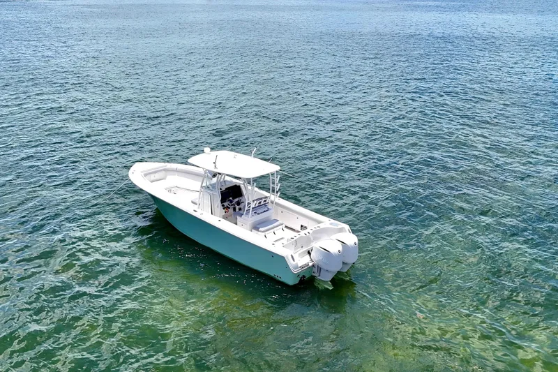 Slide: The Image of 2014 Sailfish 320 CC boat floating on clear blue water. - 4