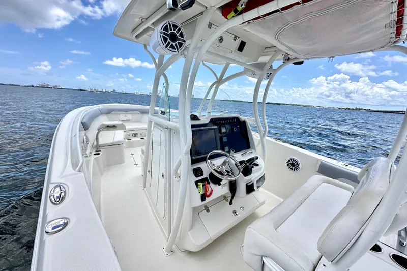Slide: The Image of 2014 Sailfish 320 CC boat interior with steering console, on calm ocean waters. - 7
