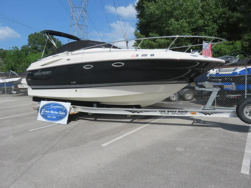 Slide: The Image of 2004 Monterey 245 Cruiser boat on trailer in parking lot, displayed for sale. - 1