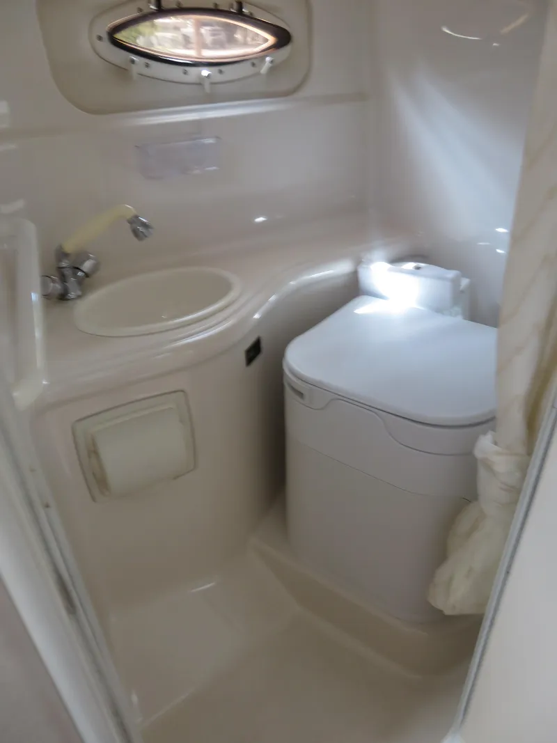 Slide: The Image of 2004 Monterey 245 Cruiser bathroom with sink, toilet, and porthole window. - 11