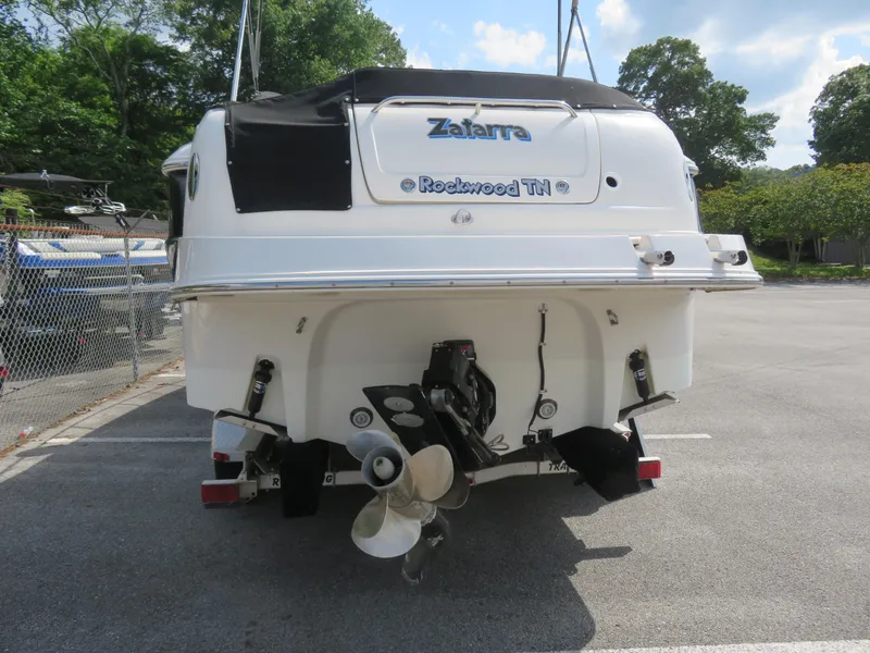 Slide: The Image of 2004 Monterey 245 Cruiser boat rear view in parking lot, featuring dual propellers. - 12