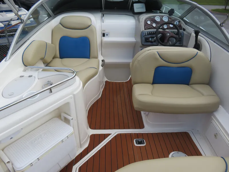 Slide: The Image of 2004 Monterey 245 Cruiser interior with beige and blue seating, wooden flooring, and control panel. - 2
