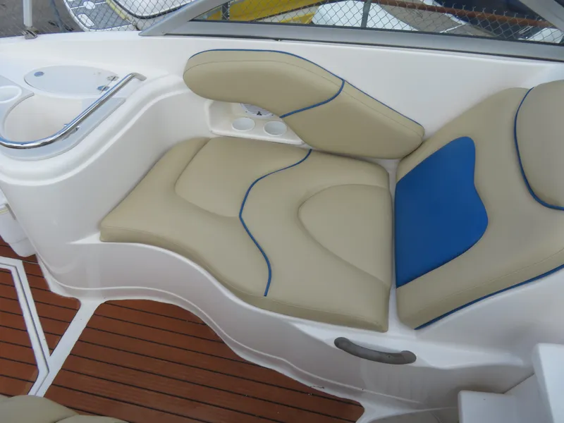 Slide: The Image of 2004 Monterey 245 Cruiser interior with beige and blue cushioned seating, wooden deck. - 5