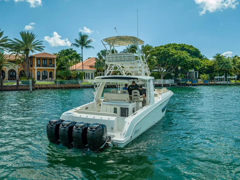 Slide: The Image of 2016 Boston Whaler 420 Outrage boat cruising on a scenic waterfront with luxury homes. - 11