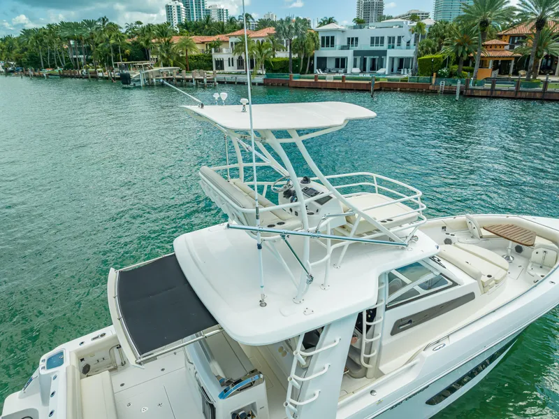 Slide: The Image of 2016 Boston Whaler 420 Outrage boat on a scenic waterfront with luxury homes. - 22