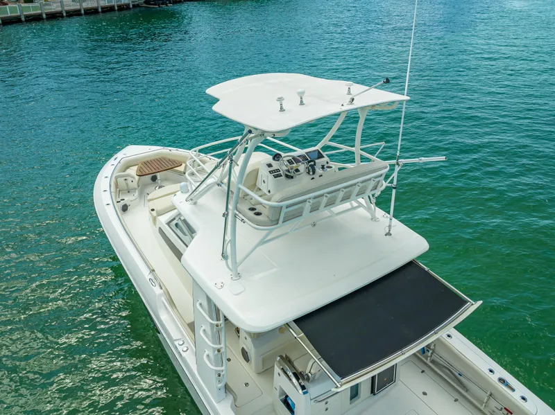 Slide: The Image of 2016 Boston Whaler 420 Outrage boat on clear turquoise water, featuring a spacious deck. - 24