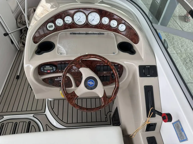 Slide: The Image of 2006 Four Winns 290 Horizon boat dashboard with wood accents and steering wheel. - 18