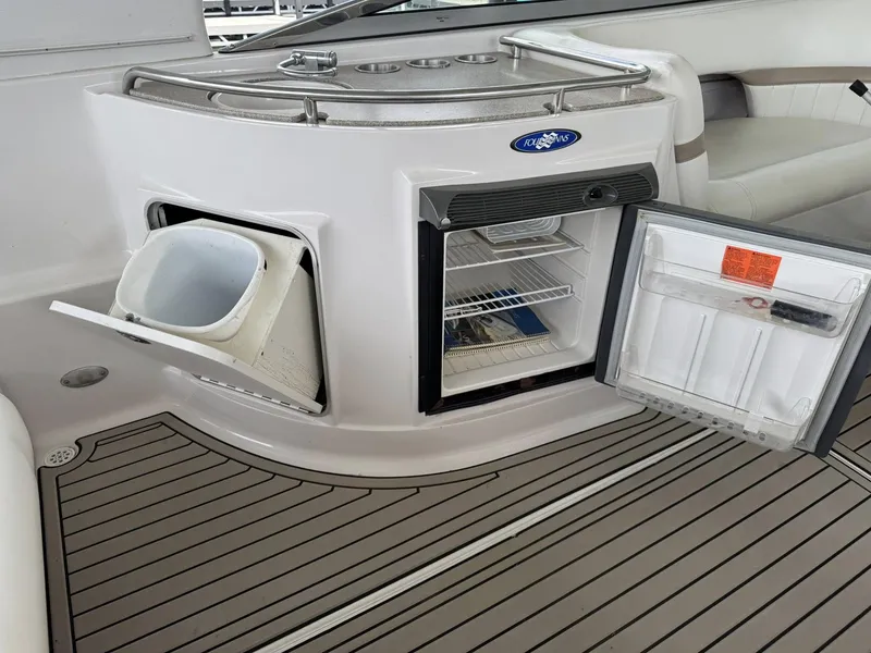 Slide: The Image of 2006 Four Winns 290 Horizon boat interior with open fridge and storage compartment. - 19