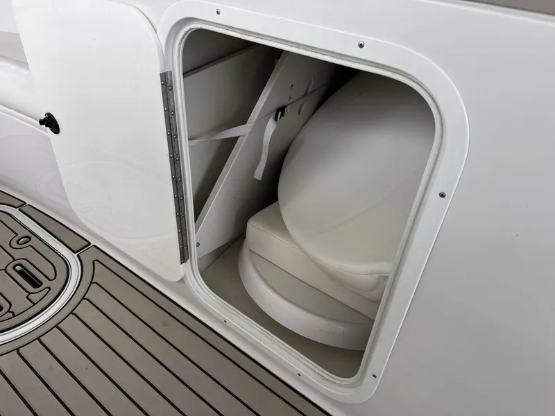 Slide: The Image of Storage compartment on 2006 Four Winns 290 Horizon boat, featuring white interior and deck flooring. - 9