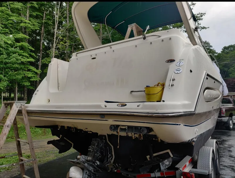 Slide: The Image of 2000 Maxum 2800 SCR boat on trailer, rear view, with trees in background. - 10