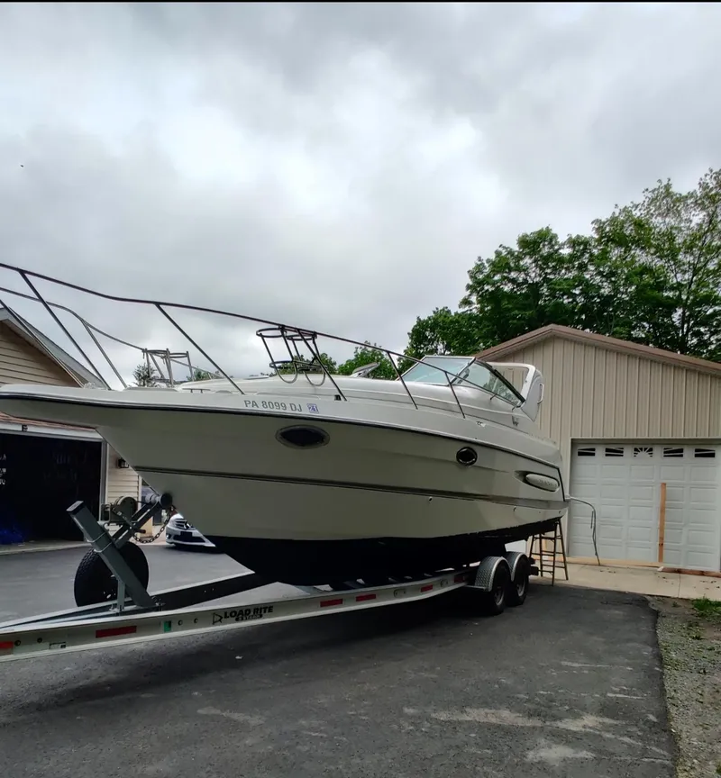 Slide: The Image of 2000 Maxum 2800 SCR boat on trailer near garage, overcast sky. - 11