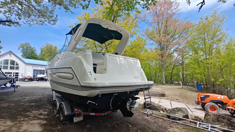 Slide: The Image of 2000 Maxum 2800 SCR boat on trailer, surrounded by trees and a clear blue sky. - 13
