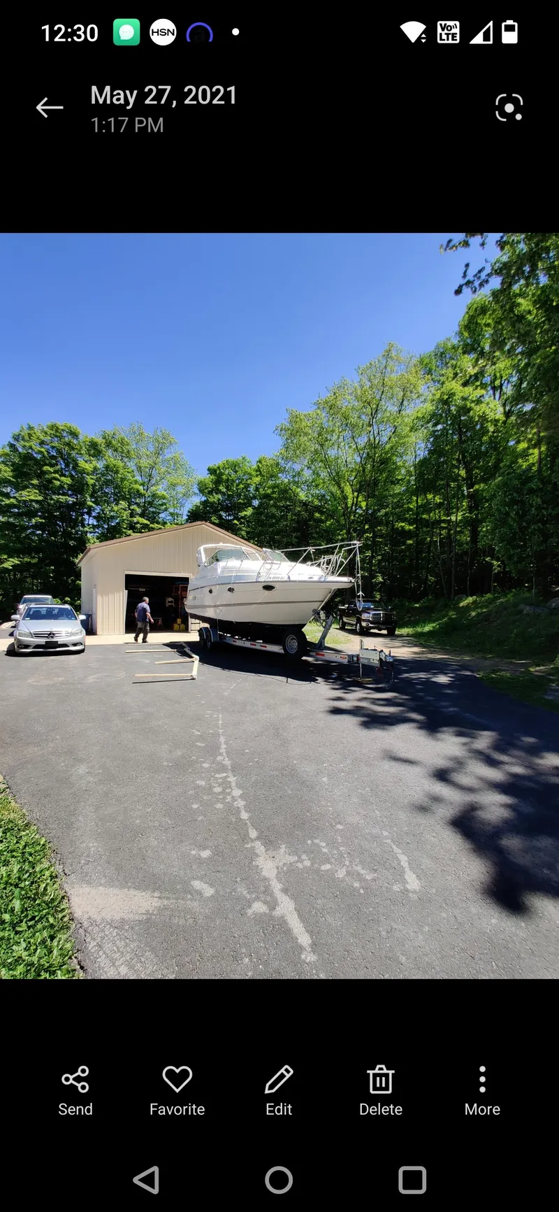 Slide: The Image of 2000 Maxum 2800 SCR boat on trailer in driveway near garage, surrounded by trees. - 14