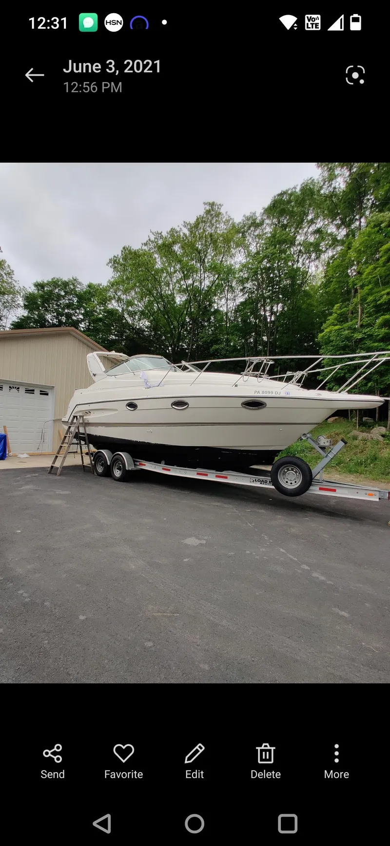 Slide: The Image of 2000 Maxum 2800 SCR boat on trailer, parked near garage, surrounded by trees. - 17
