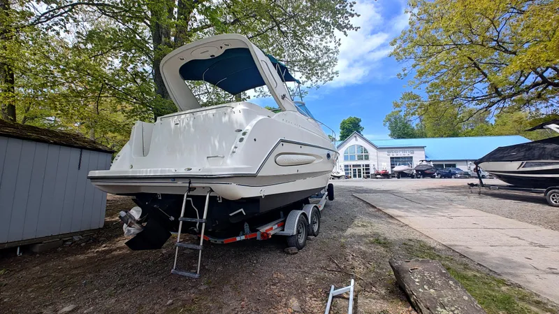 Slide: The Image of 2000 Maxum 2800 SCR boat on trailer, parked outdoors near a building. - 25