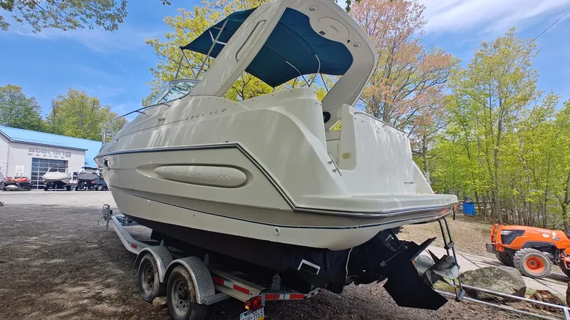 Slide: The Image of 2000 Maxum 2800 SCR boat on trailer at marina, surrounded by trees. - 26