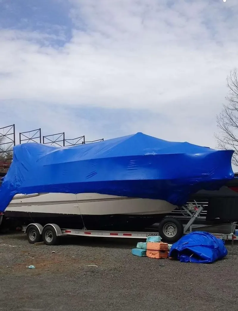 Slide: The Image of Covered 2000 Maxum 2800 SCR boat on trailer with blue tarp, parked outdoors. - 3
