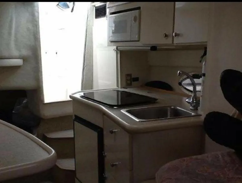 Slide: The Image of Interior of 2000 Maxum 2800 SCR boat featuring compact kitchen with sink and microwave. - 5