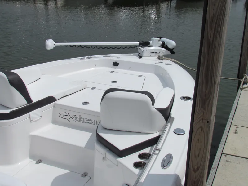 Slide: The Image of 2024 Crevalle 26 HCO boat docked, featuring sleek white design and modern seating. - 1