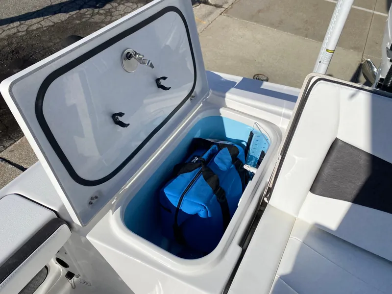 Slide: The Image of 2024 Crevalle 26 HCO boat storage compartment with blue bag inside. - 3