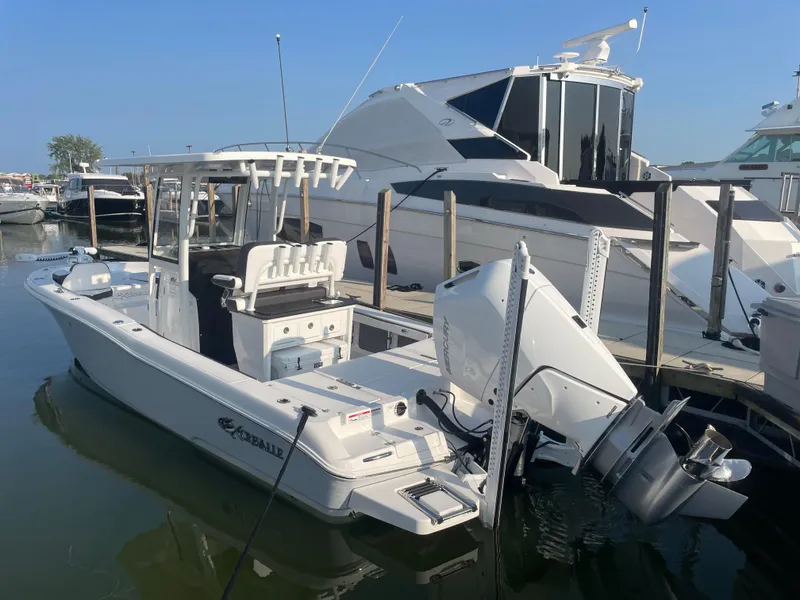 Slide: The Image of 2024 Crevalle 26 HCO boat docked at marina, featuring sleek design and powerful outboard motor. - 8