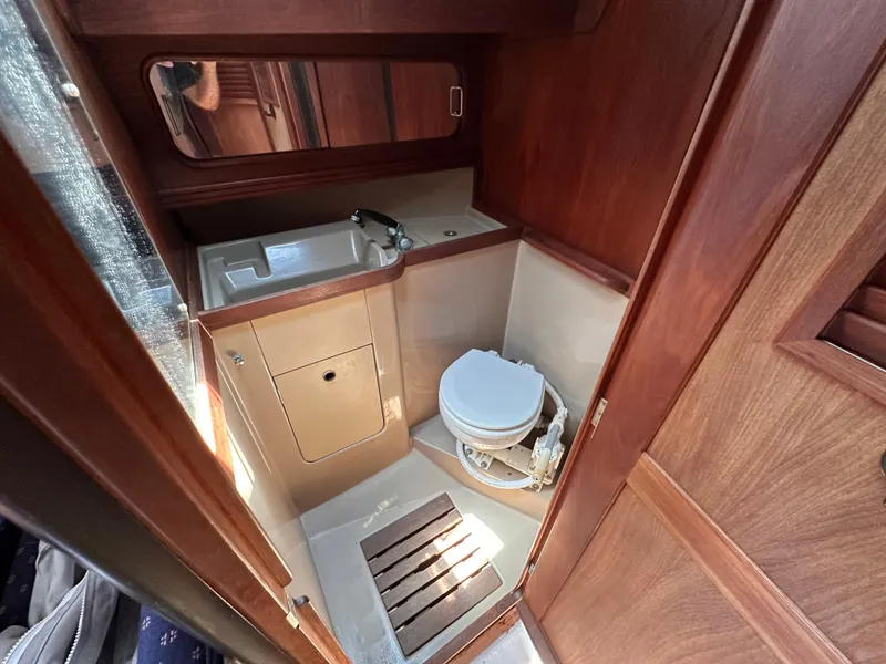Slide: The Image of 1987 C&C 34 yacht bathroom with sink, toilet, and wooden accents. - 13