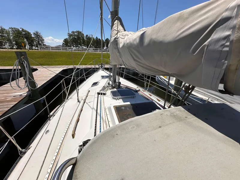 Slide: The Image of 1987 C&C 34 sailboat docked, featuring deck and mast under clear blue sky. - 3