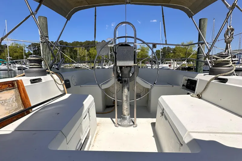 Slide: The Image of 1987 C&C 34 sailboat cockpit with steering wheel, docked at marina. - 4