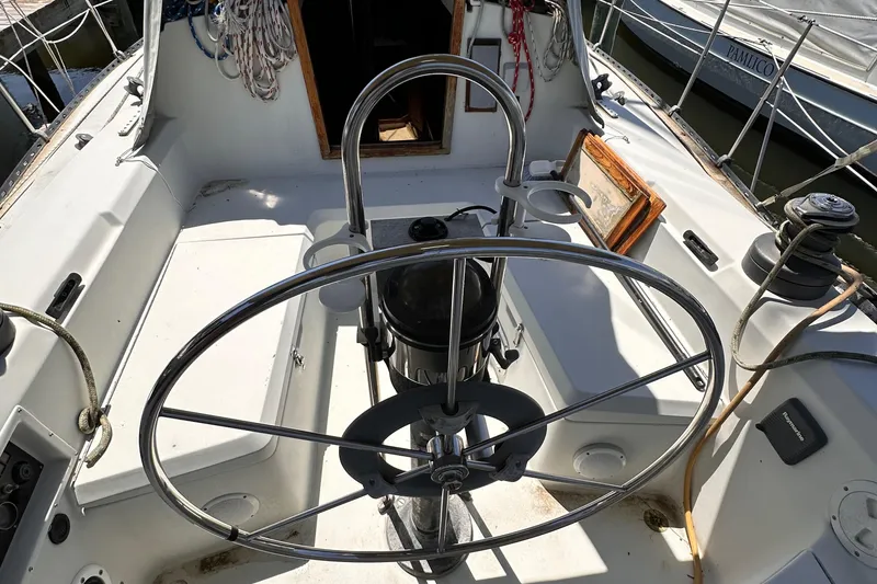 Slide: The Image of 1987 C&C 34 sailboat cockpit with steering wheel and nautical equipment. - 5