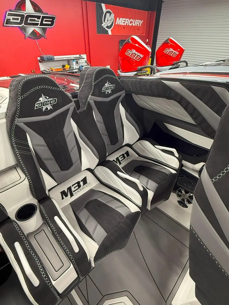 Slide: The Image of 2016 Daves Custom Boats M31 interior with sleek black and gray seating design. - 14
