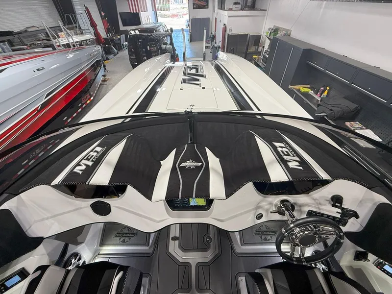 Slide: The Image of 2016 Daves Custom Boats M31 interior with sleek design and modern controls in a showroom. - 9