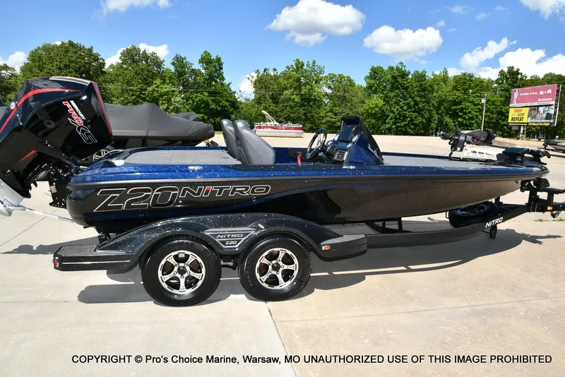 Slide: The Image of 2021 Nitro Z20 boat on trailer, parked outdoors under a clear blue sky. - 18