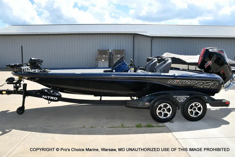 Slide: The Image of 2021 Nitro Z20 boat on trailer, parked outdoors under a cloudy sky. - 27