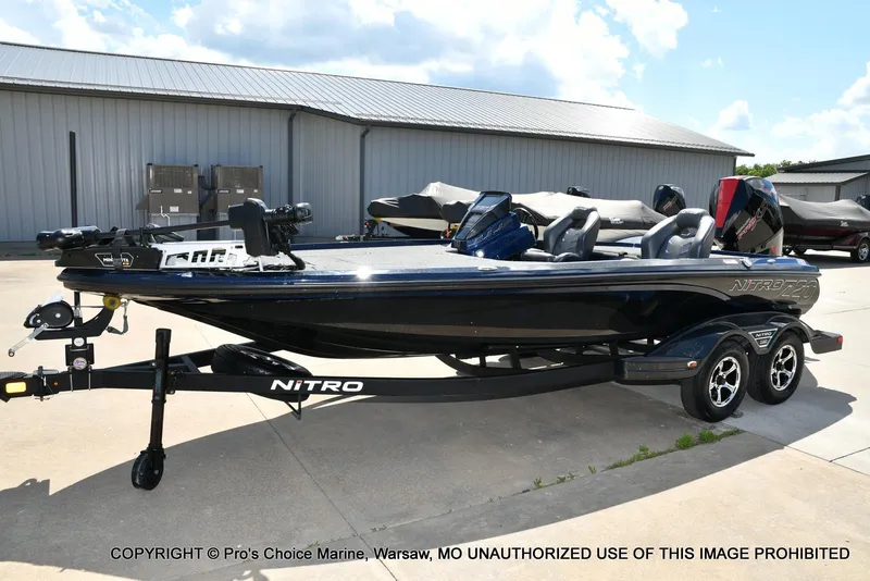 Slide: The Image of 2021 Nitro Z20 boat on trailer, parked outdoors near a warehouse. - 28