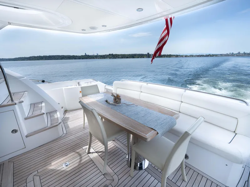 Slide: The Image of Luxurious Sunseeker Manhattan 63 yacht deck with elegant seating, table, and ocean view. - 13