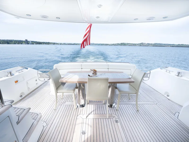 Slide: The Image of Luxurious Sunseeker Manhattan 63 yacht deck with dining area, cruising on serene waters. - 20