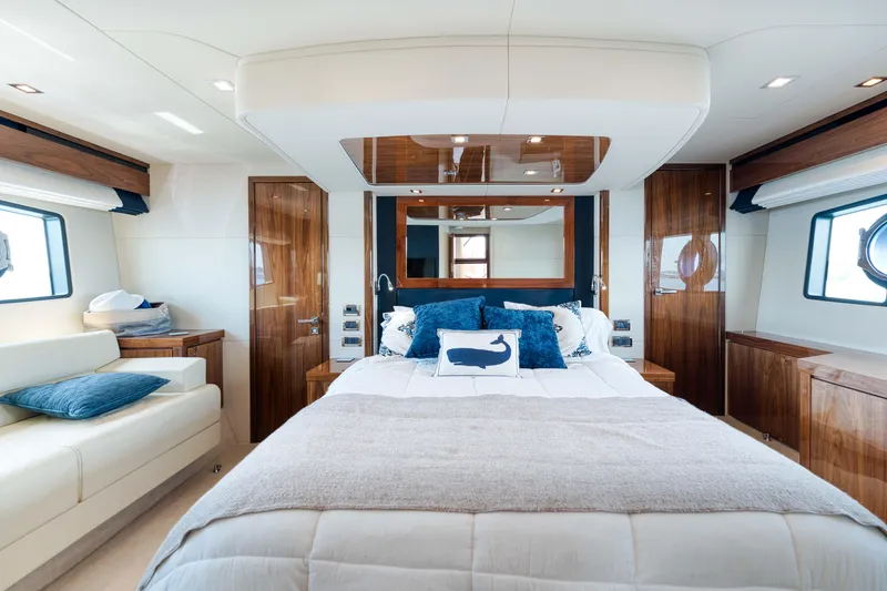 Slide: The Image of Luxurious Sunseeker Manhattan 63 yacht bedroom interior, featuring elegant wood finishes and plush bedding. - 28