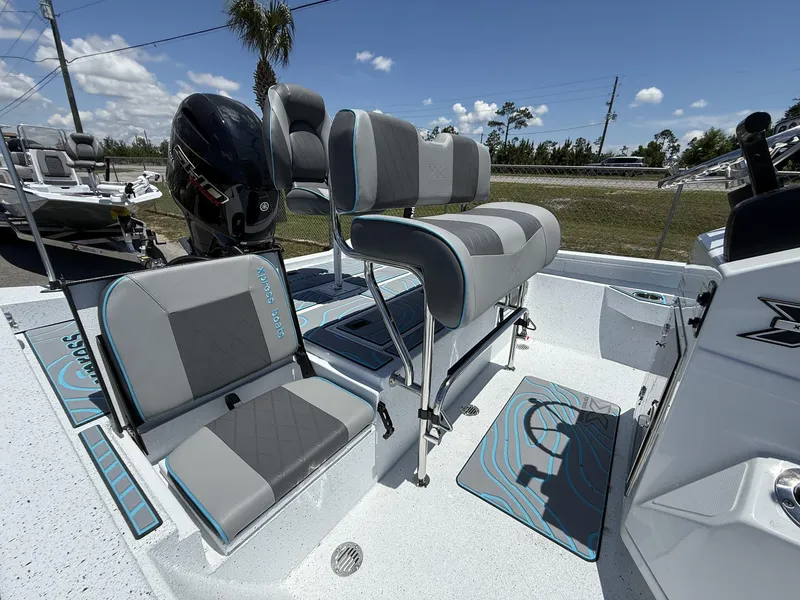Slide: The Image of 2025 Xpress Hyper-Lift Series H22B boat interior with seating and motor, under clear sky. - 3