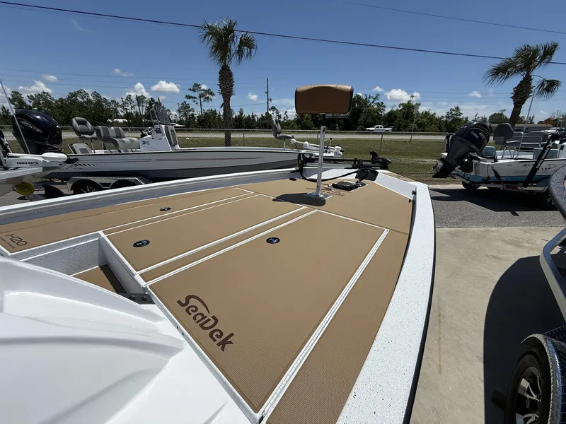 Slide: The Image of 2025 Xpress Hyper-Lift Bass Series boat with SeaDek flooring, parked outdoors under clear skies. - 4