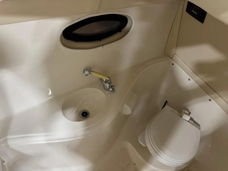 Slide: The Image of 2007 Monterey 298 boat bathroom with sink, toilet, and porthole window. - 15
