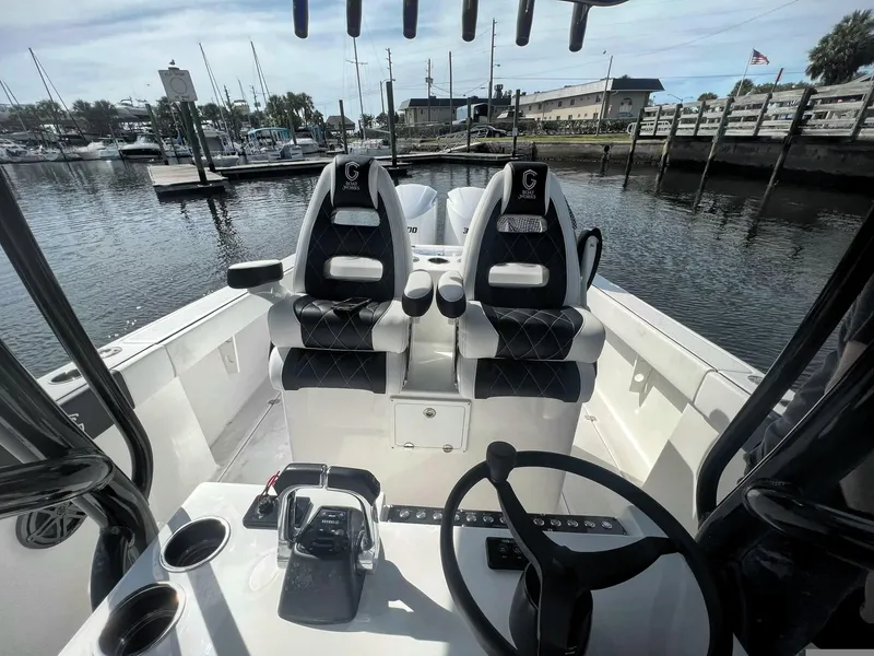 Slide: The Image of 2022 CG Boat Works 35 M-Series interior with dual seats, steering wheel, and marina view. - 41