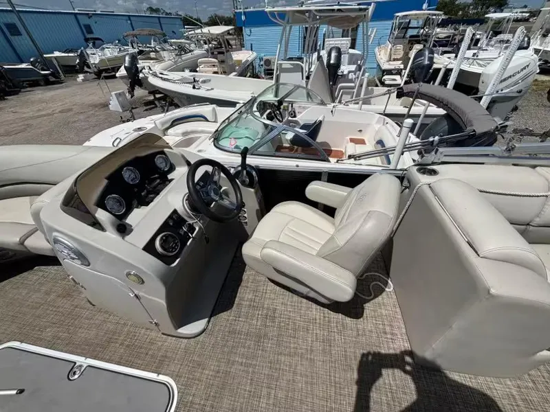 Slide: The Image of 2019 Cypress Cay Sea Breeze 212 boat interior with steering console and seating, docked among other boats. - 5