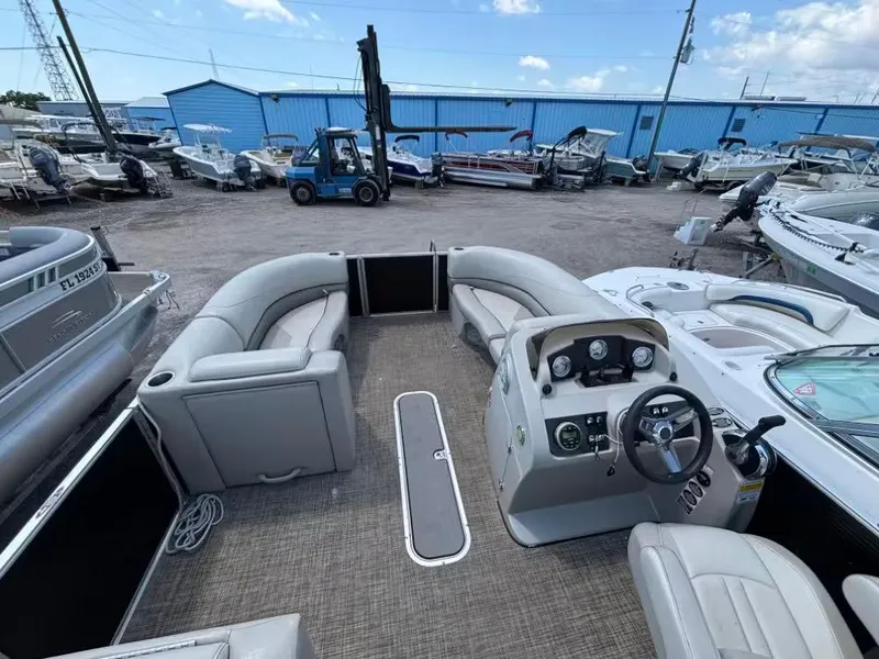 Slide: The Image of 2019 Cypress Cay Sea Breeze 212 pontoon boat interior with helm and seating, docked at marina. - 6