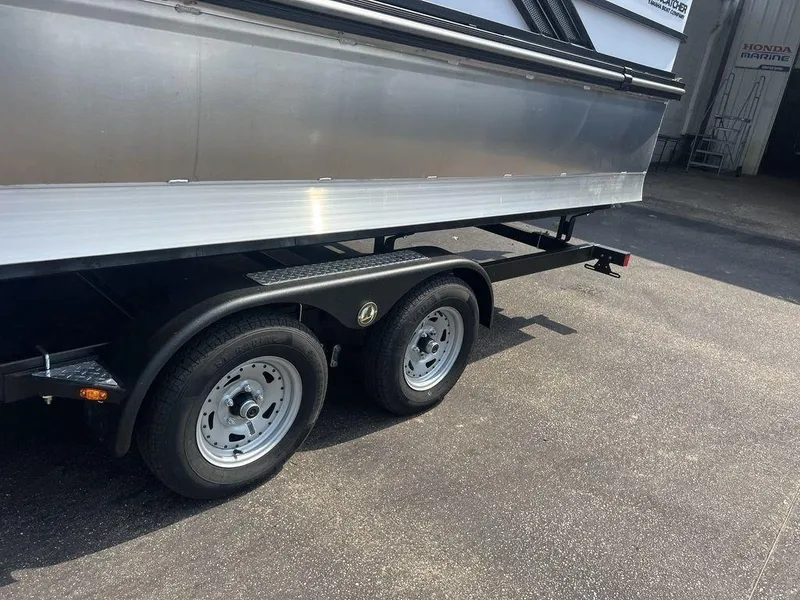 Slide: The Image of Trailer of 2025 SunCatcher Fusion 322 FC boat on pavement. - 16