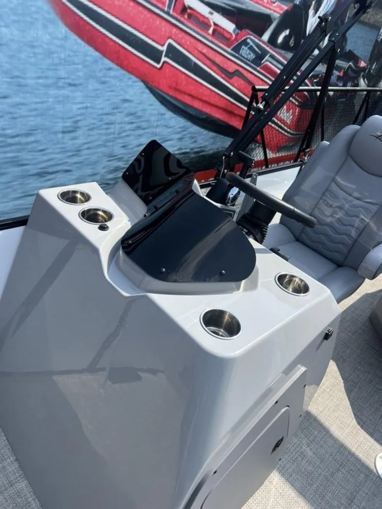 Slide: The Image of 2025 SunCatcher Fusion 322 FC boat console with cup holders and steering wheel. - 27