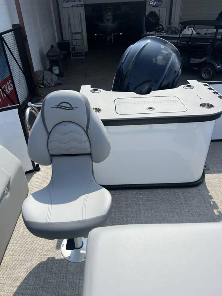 Slide: The Image of 2025 SunCatcher Fusion 322 FC boat interior with gray seating and motor. - 32