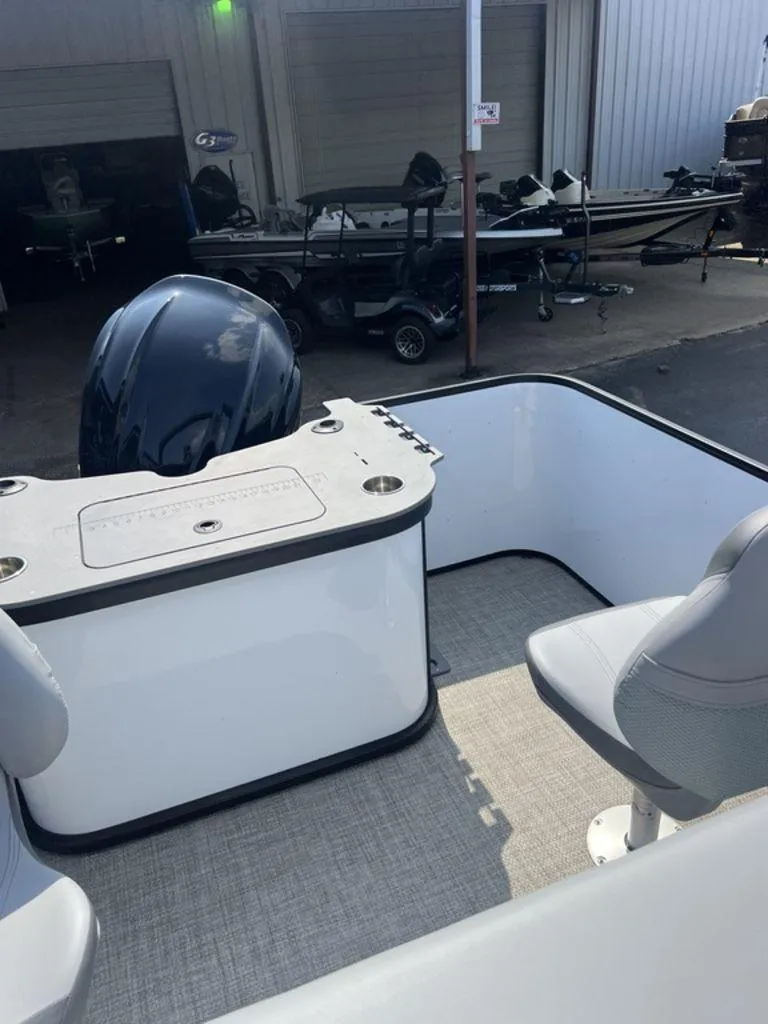 Slide: The Image of 2025 SunCatcher Fusion 322 FC boat interior with seating and motor, in a showroom setting. - 33